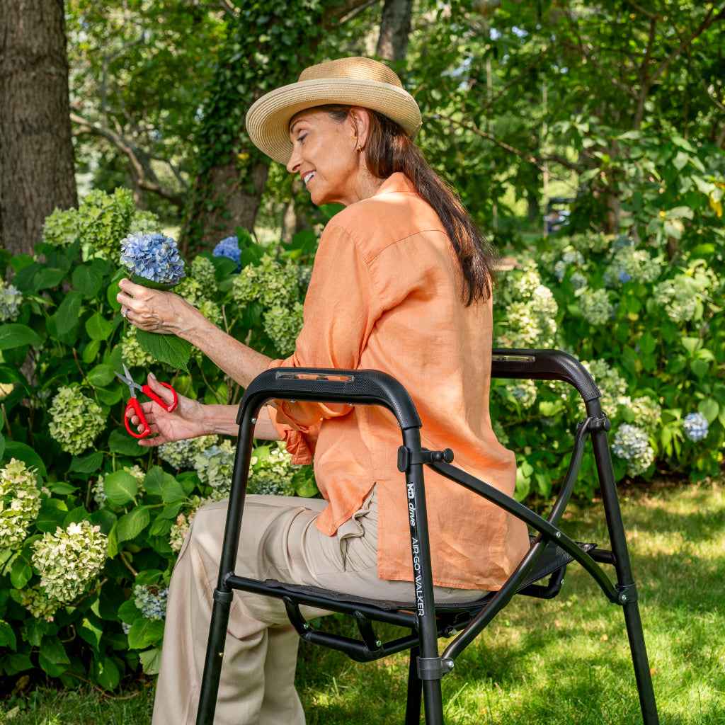Woman seated on an MD by Drive Air-Go walker in a garden